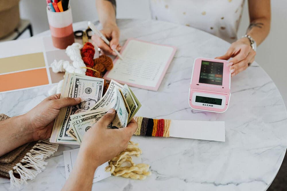 A couple sits down to hash out their new combined budget using the cash envelope system