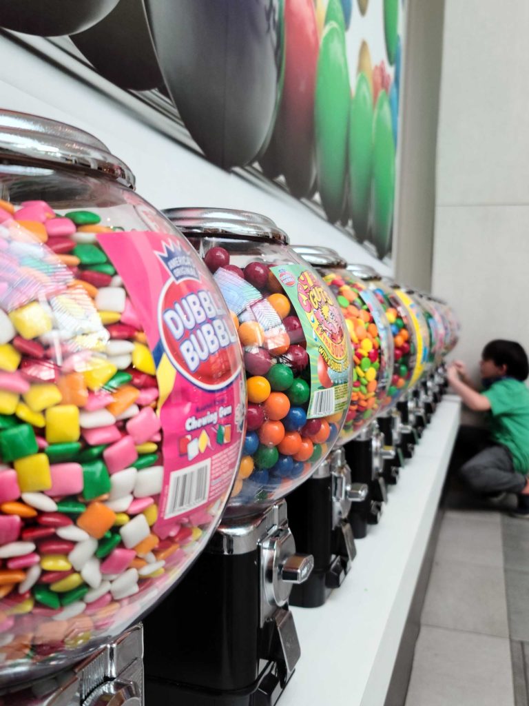 Several bulk vending machines with gumballs and various candies