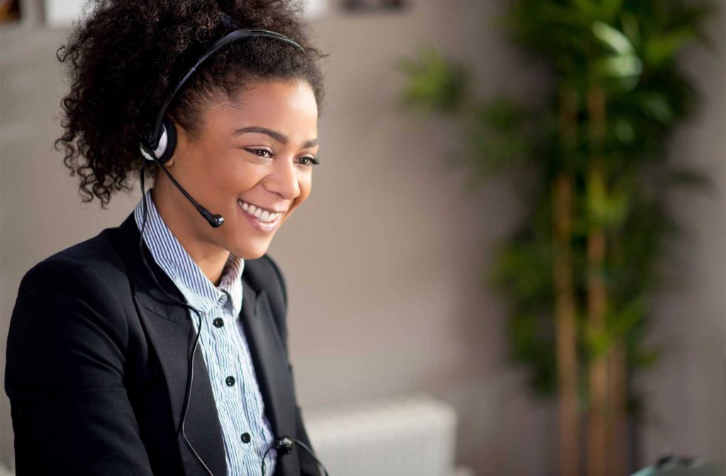 Smiling woman handling phone communications from home