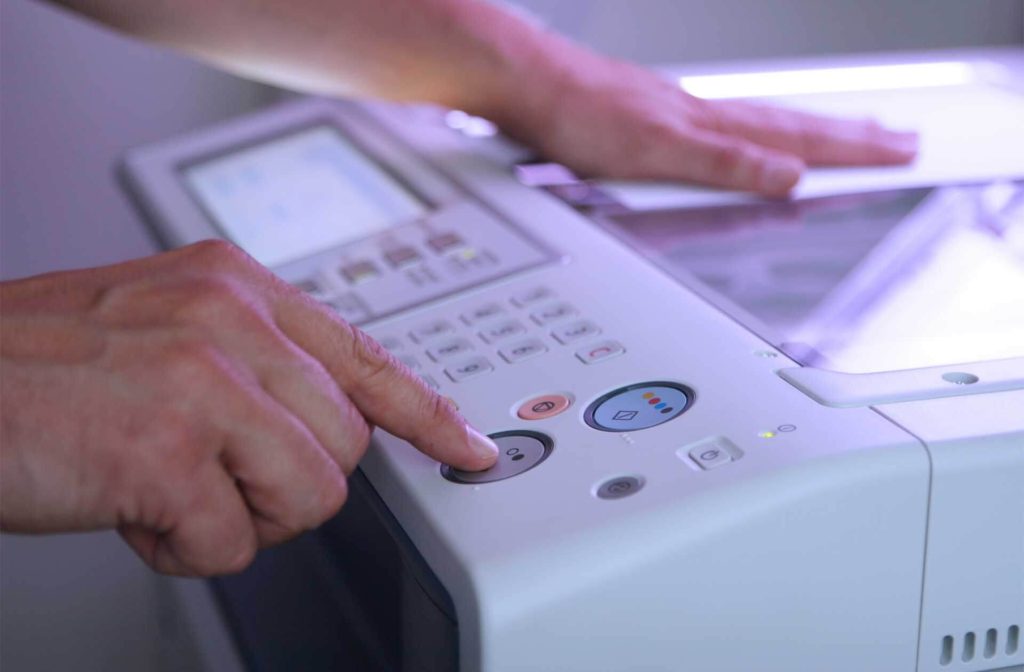 Man making copies at his home office as a remote assistant