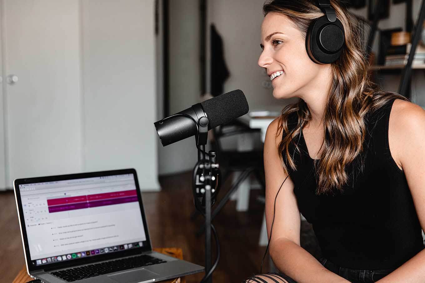 Female podcaster smiling while recording a new episode