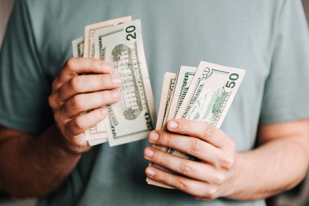 Man paying in all cash to adhere to the cash envelope system