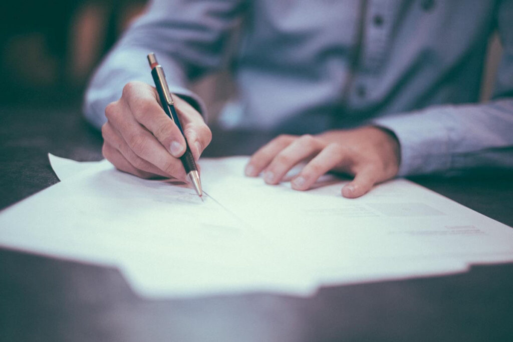 Man signing an NDA before discussing a potential invention idea