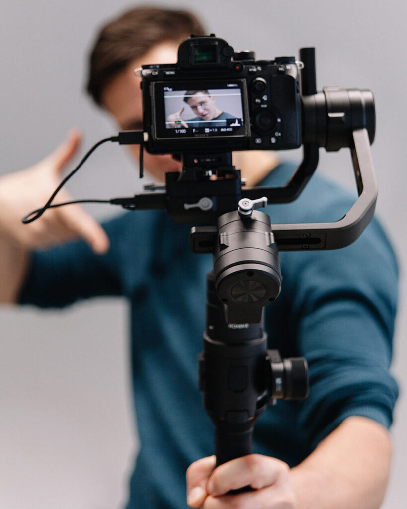 Man filming an online course with a DSLR camera on a tripod